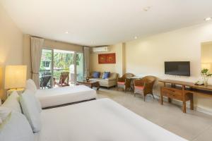 a hotel room with two beds and a television at Bella Villa Cabana in Naklua 