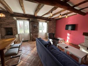 a living room with a blue couch and a tv at Oktheway Casa da Escola in Sarria