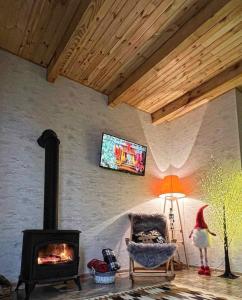 a living room with a fireplace and a tv on the wall at Iano in Oni