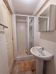 uma casa de banho com um lavatório e um chuveiro em Private Guest Suite with 24hr Electricity, East London em East London