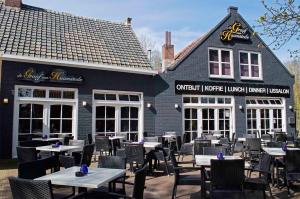 a restaurant with tables and chairs in front of a building at Bed&Breakfast Jonker in Burgh Haamstede