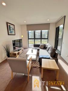 a living room with a couch and a table at Bright in Braddon! 1 bd 1bth Apt in Canberra