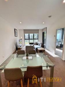 a living room with a glass table and chairs at Bright in Braddon! 1 bd 1bth Apt in Canberra