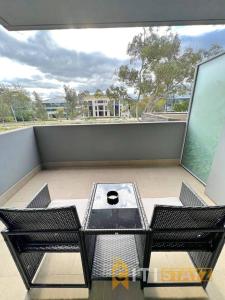 a balcony with a table and chairs on a balcony at Bright in Braddon! 1 bd 1bth Apt in Canberra