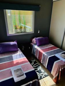 2 camas en una habitación con ventana en Balcon de Belgrano en Salta