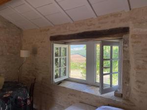 - une chambre avec une fenêtre donnant sur un vignoble dans l'établissement Une Maison de campagne en Bourgogne du Sud, à Tournus
