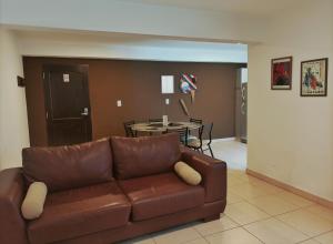 sala de estar con sofá marrón y mesa en Carnaval p/6 - 2 dorm - Amplio y a 5' del centro en Salta