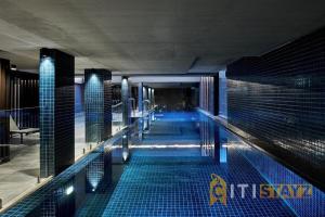 una piscina en un edificio con azulejos azules en Majestic at Midnight! Luxe 1 bd 1bth 1csp Apt, en Canberra