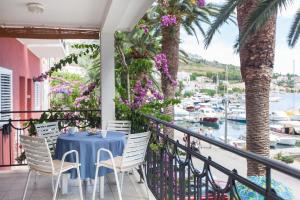 a blue table and chairs on a balcony with a marina at Villa Helena in Podgora