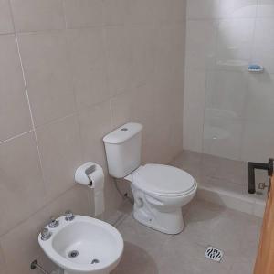 a white bathroom with a toilet and a sink at Lujan de Cuyo Mendoza in Ciudad Lujan de Cuyo