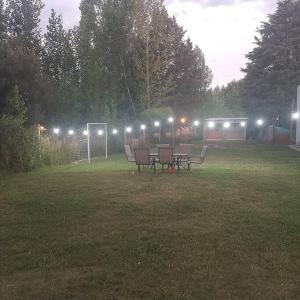 a group of chairs and tables in a field with lights at Lujan de Cuyo Mendoza in Ciudad Lujan de Cuyo