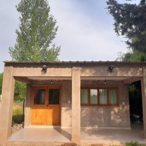 mały dom z dużymi drewnianymi drzwiami w obiekcie Lujan de Cuyo Mendoza w mieście Lujan de Cuyo