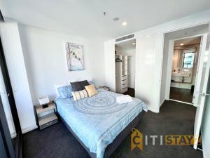 坎培拉的住宿－Light & Lovely in Canberra's CBD - 1BR Apt w/Carsp，一间卧室配有一张带蓝色棉被的床