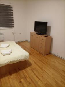 a bedroom with a bed and a flat screen tv at Terza in Sarajevo