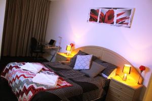a bedroom with a bed with two lamps on it at Perfectly Located Modern Apartment - Canberra CBD in Canberra