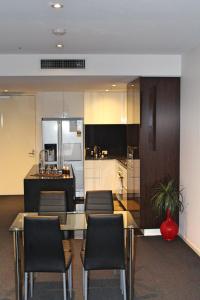 a kitchen with a table and some chairs at Perfectly Located Modern Apartment - Canberra CBD in Canberra
