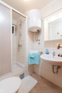 a white bathroom with a sink and a shower at Villa Helena in Podgora +20 photos