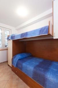 a bedroom with two bunk beds with blue sheets at Villa Helena in Podgora