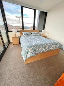 a bedroom with a bed in a room with windows at Spacious & Open 2 bd 2bth 2crsp apt - Dickson CBD in Canberra