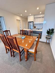 a dining room with a wooden table and chairs at Spacious & Open 2 bd 2bth 2crsp apt - Dickson CBD in Canberra
