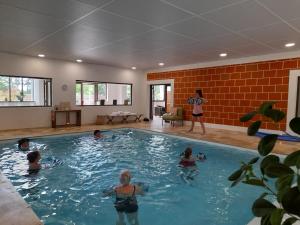 a group of people swimming in a swimming pool at Les Lodges du golf de la Marterie in Saint-Félix-de-Reillac-et-Mortemart