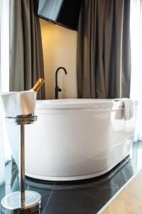 a white bath tub in a bathroom with a shower at Hotel Master in Brescia