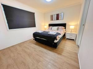 a bedroom with a bed and a large screen on the wall at Beautiful & enclosed, 1 bd 1 bth - close to CBR Hospital in Phillip