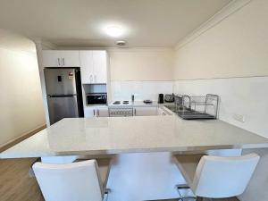 a kitchen with a large counter top with white appliances at Beautiful & enclosed, 1 bd 1 bth - close to CBR Hospital in Phillip
