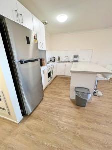 a kitchen with a stainless steel refrigerator and a counter at Beautiful & enclosed, 1 bd 1 bth - close to CBR Hospital in Phillip