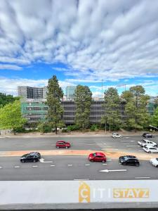 a parking lot with cars and buildings in the background at Enchanting in Red - 1bd 1bth 1csp in Canberra