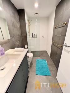 a bathroom with a shower and a toilet and a sink at Enchanting in Red - 1bd 1bth 1csp in Canberra