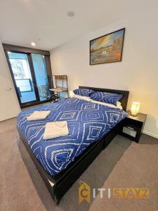 - une chambre avec un lit et une couette bleue dans l'établissement Beauty in Blue! 1bd 1bth 1crsp Apt - Great Location!, à Canberra