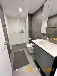 La salle de bains est pourvue d'un lavabo, de toilettes et d'une douche. dans l'établissement Beauty in Blue! 1bd 1bth 1crsp Apt - Great Location!, à Canberra