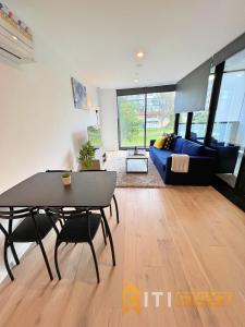 a living room with a table and a blue couch at Beauty in Blue! 1bd 1bth 1crsp Apt - Great Location! in Canberra