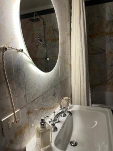 La salle de bains est pourvue d'un lavabo et d'un miroir. dans l'établissement Rome s Suite Bramante, à Rome