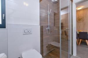 a bathroom with a shower with a glass door at House Torre Apartments in Mali Lošinj