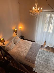 a bedroom with a large bed with a chandelier at Rome s Suite Bramante in Rome