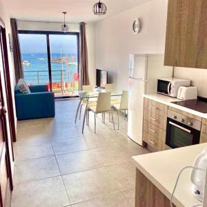 a kitchen and living room with a view of the ocean at F1 - Modern two bedrooms Flat sea View, St Julians in St Julian's