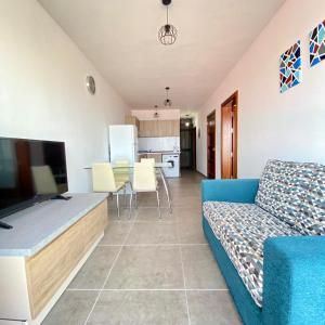 a living room with a blue couch and a kitchen at F1 - Modern two bedrooms Flat sea View, St Julians in St Julian's