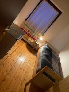 a small room with a bed and a window at La casa di carlo in Lavarone