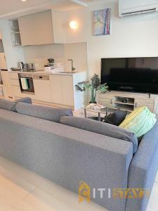 a living room with a blue couch and a kitchen at Splendid 2bd 1bth 1csp Apt - Superb CBD Location in Canberra