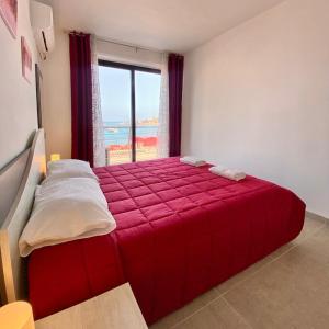 a bedroom with a red bed with a view of the ocean at F1 - Modern two bedrooms Flat sea View, St Julians in St Julian's