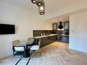 a kitchen with a table and chairs and a television at Leith Street Suite in Edinburgh