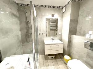 a bathroom with a shower and a sink and a toilet at Apartament Superior Lazurowy Przy Plaży in Kołobrzeg