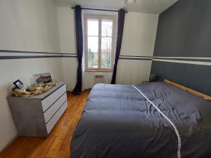 a bedroom with a bed and a dresser and a window at Kilomètre 99 in Pont-sur-Yonne