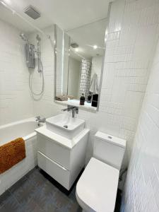 a white bathroom with a sink and a toilet at Leith Street Suite in Edinburgh +13 photos