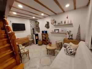 sala de estar con sofá y TV en La Casa de Sara, en Llánaves de la Reina