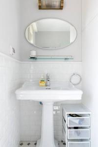 a white bathroom with a sink and a mirror at New 2bedroom apt, view to the sea and Neve Tzedek in Tel Aviv