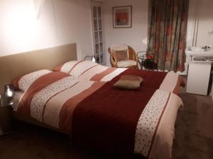ein Schlafzimmer mit einem großen Bett mit einer roten und weißen Decke in der Unterkunft Benboverijssel in Haaksbergen