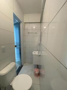 a white bathroom with a toilet and a sink at Apartamento Onda Azul in Balneário Camboriú